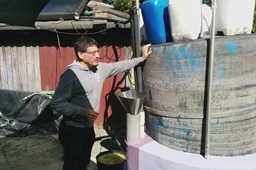 TH Culhane in front of biogas system